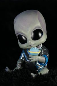 Adorable jouet alien vêtu d'une tenue spatiale avec un petit accessoire UFO ludique.