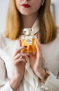 Elegant woman holding Chanel No.5 Eau de Parfum, mettant en valeur le luxe et le style.