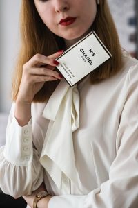 Sophistiquée tenant une boîte de parfum, mettant en valeur l'élégance et le luxe