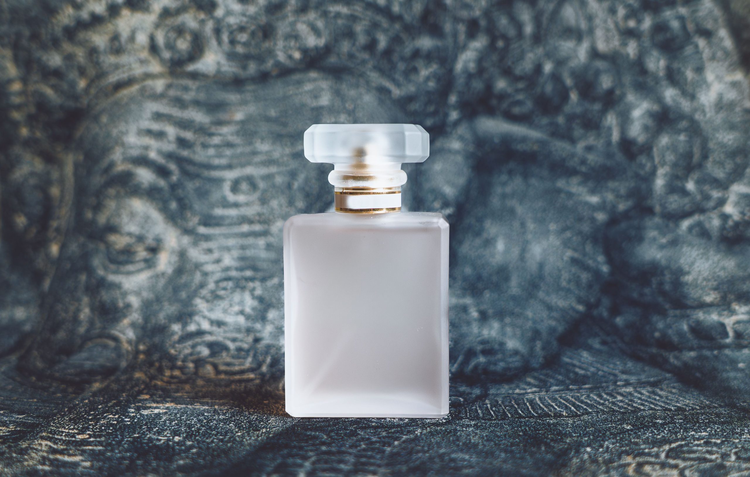 Flacon de parfum givre sur fond texture