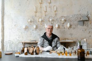 Parfumeur entouré de flacons de parfum de niche