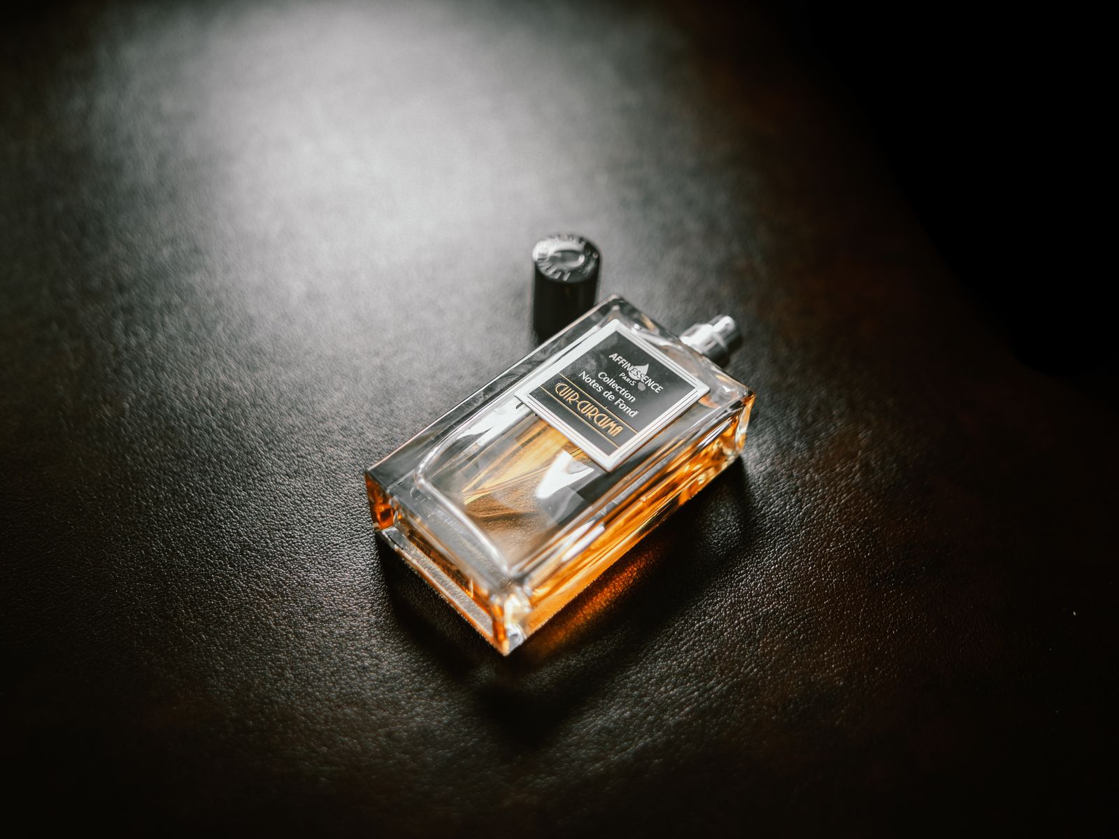 Flacon de parfum élégant sur fond sombre texturé