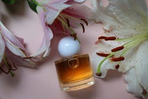 Flacon de parfum entouré de fleurs roses